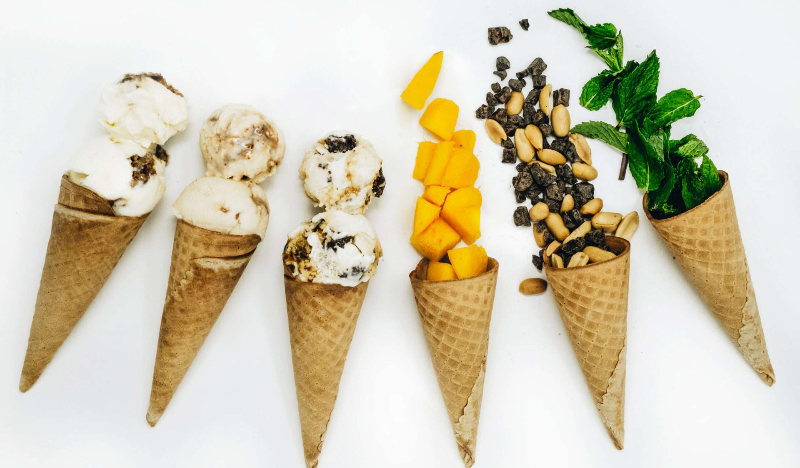 scoops of ice cream and toppings in ice cream cones