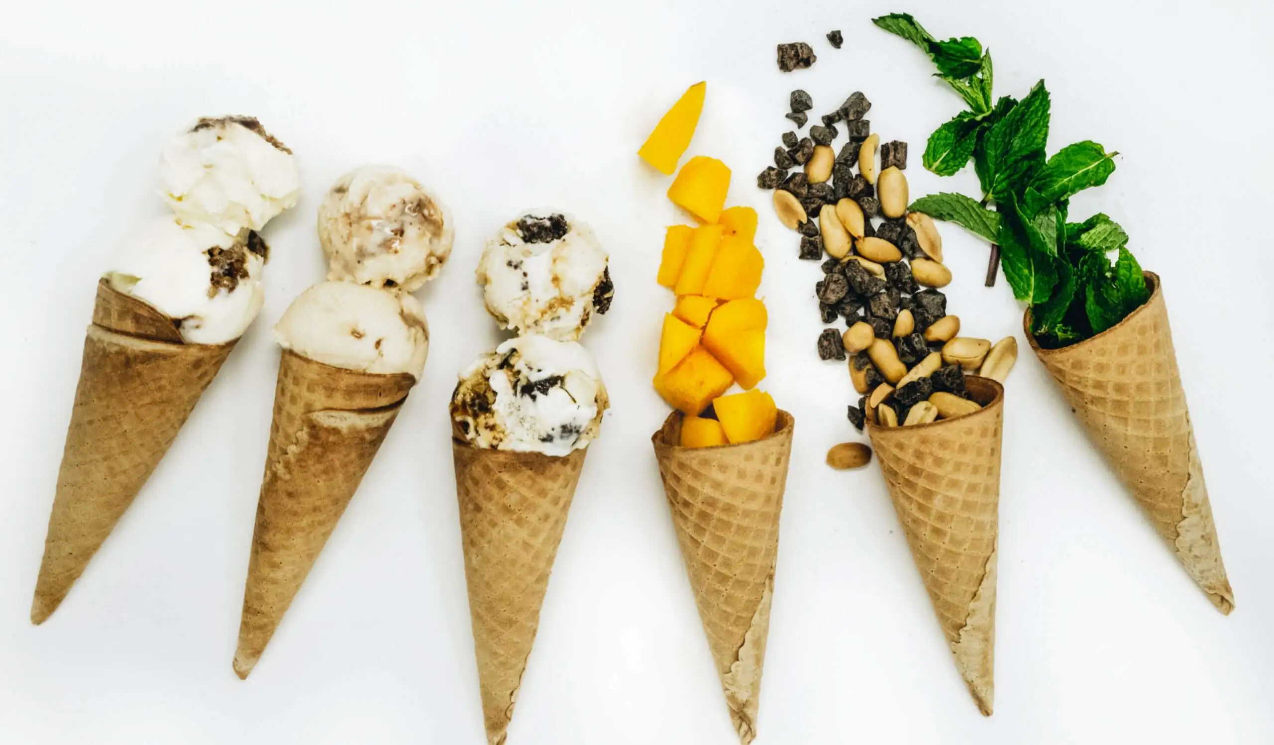 scoops of ice cream and toppings in ice cream cones